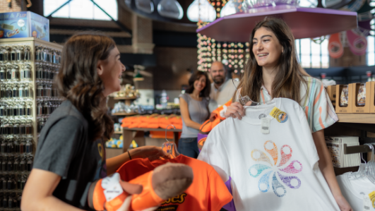 Two sisters browsing Hersheypark merchandise while mother and father watch from the distance.
